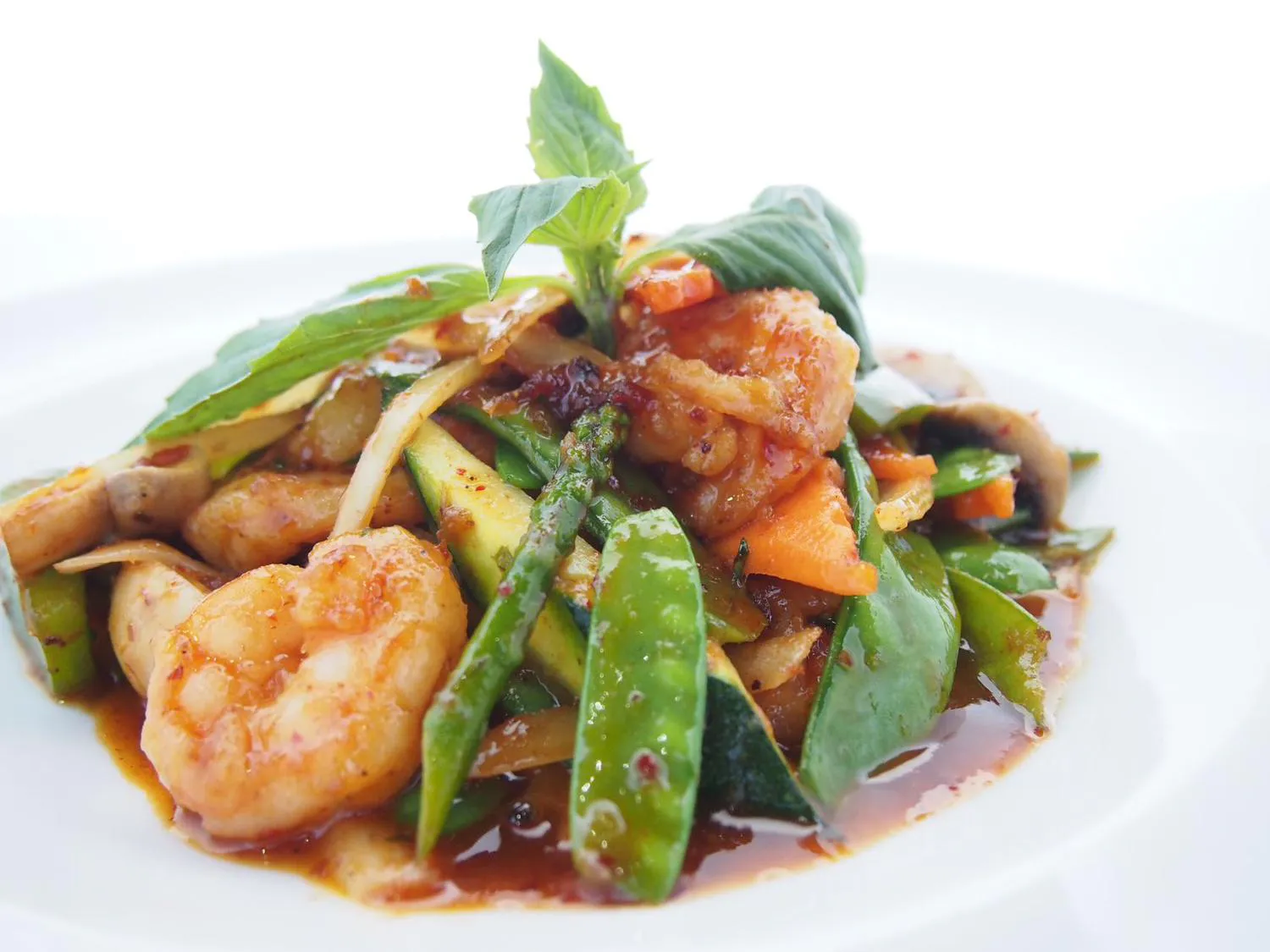 Stir fried shrimp with mixed vegetables in savory sauce on white plate